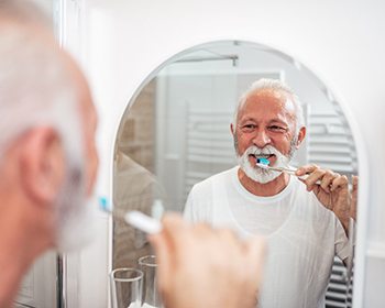 man maintaining oral hygiene after working with an implant dentist in Lincoln