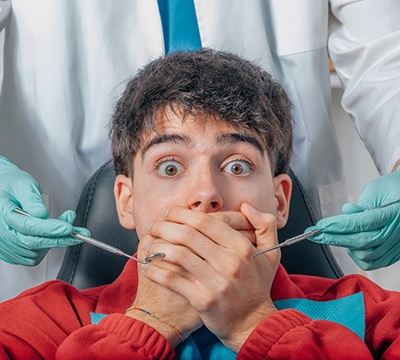 nervous dental patient covering his mouth