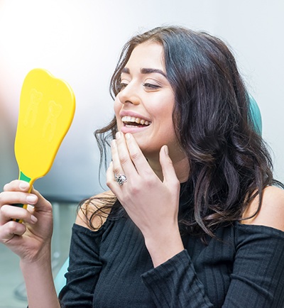 woman checking smile in yellow mirror