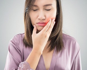 young woman holding her mouth from wisdom tooth pain