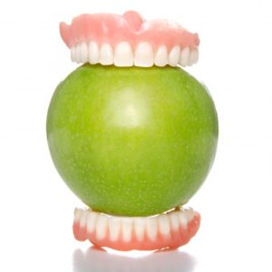 dentures around an apple
