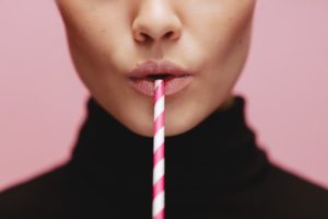 woman drinking through a straw
