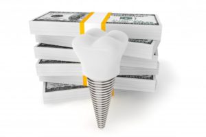 dental implant in front of a pile of money